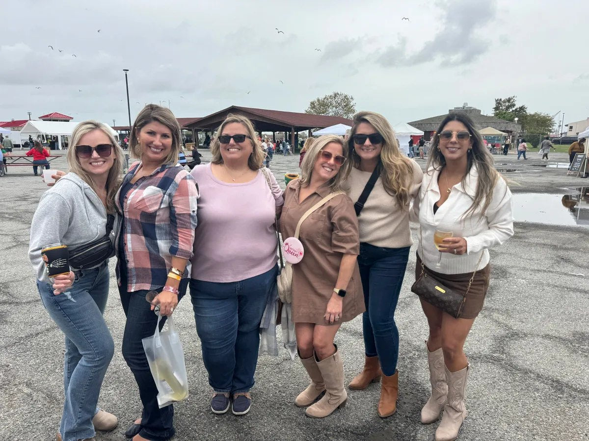 Six friends smiling together at a Tipsy Teacher festival stop