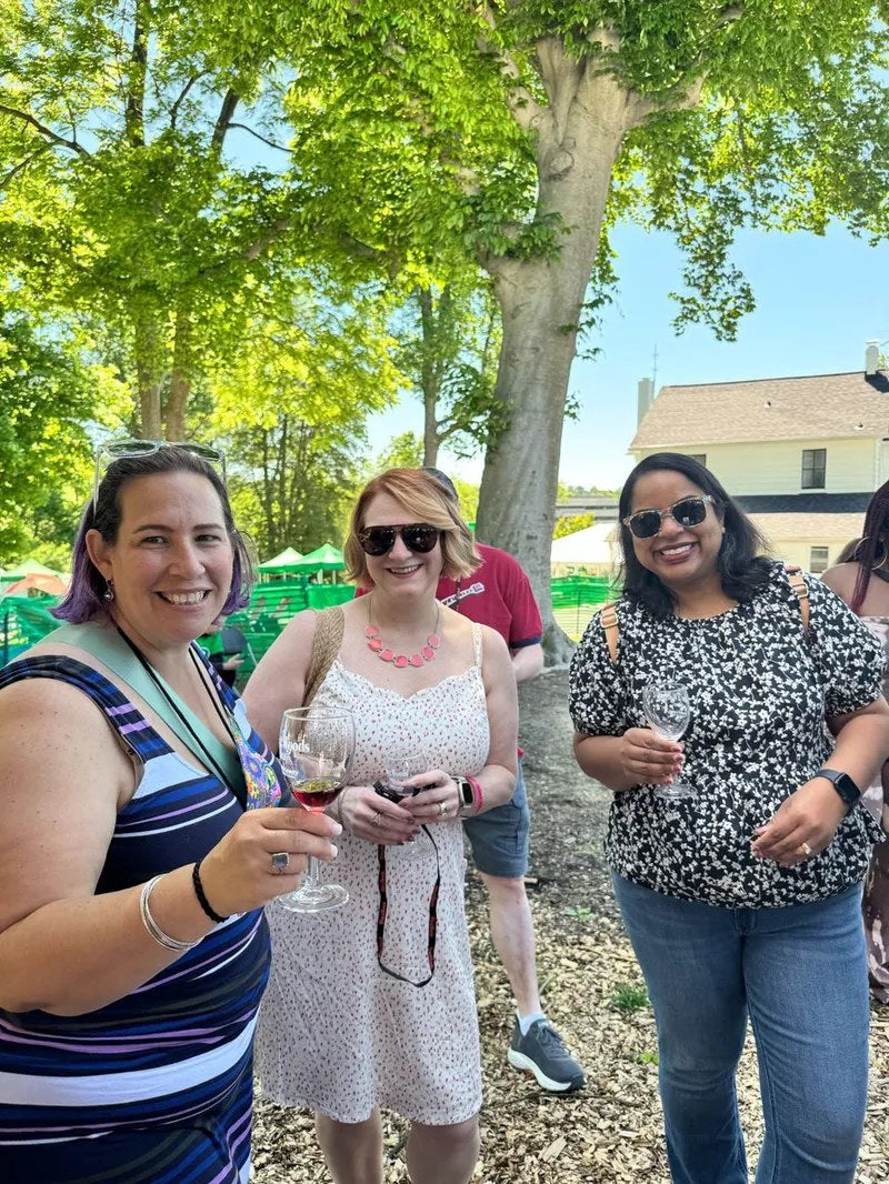 Three friends with glasses of Tipsy Teacher wine